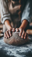Close up of baker gently kneading whole wheat dough on floured surface, preparing to make homemade bread