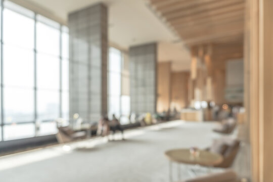Blurred business office building lobby or hotel blur background interior view toward reception hall, modern luxury lounge, white room space with blurry corridor and glass wall