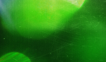 Blurred green light streak combined with grainy noise, faded film marks on black. Faded retro bokeh.