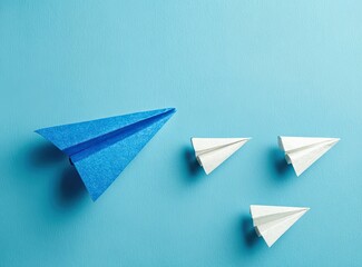 Blue paper airplane leading white paper airplanes on a light-blue background