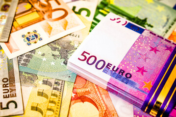 A pack of European currency lies on the background of the Euro
