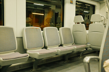 Empty train interior with gray seats at night
