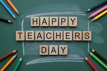 Happy Teachers Day message with colored pencils on green board