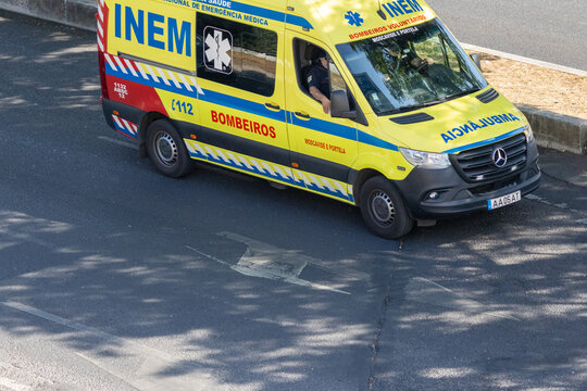 Portuguese inem ambulance driving on city asphalt during the day