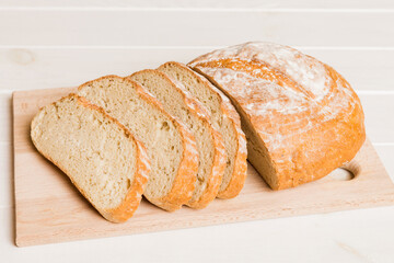 Assortment of freshly sliced baked bread with napkin on rustic table top view. Healthy unleavened bread. French bread slice