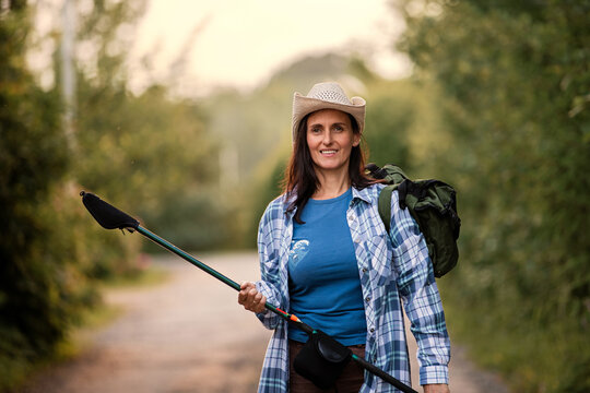 Middle aged woman in a straw hat goes fishing