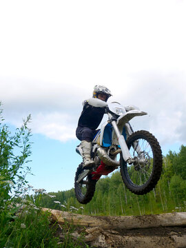Motocross Mayhem: Dirt Bike Rider Jumps Over Logs