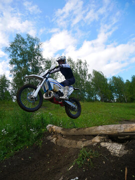Motocross Action: Dirt Bike Rider Jumping Over Log