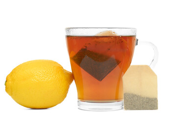 A cup of brewed instant tea in tea bags on a white background with lemon,