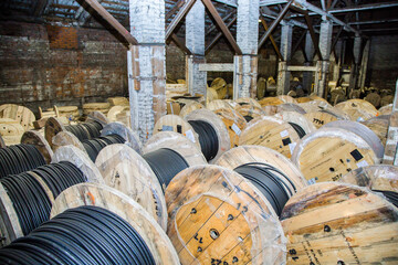 Large wooden industry cable reel for storing electrical wire. Industrial storage warehouse with...