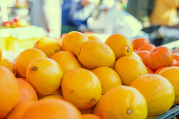 Fresh lemons are stacked on supermarket shelf and ready for purchase. Each lemon is ripe and full...