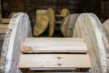 Wooden cable reel in a factory storage building. Construction material for industrial use. Empty...