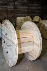 Large empty wooden reel for cable, wire, or rope storage in warehouse or industrial factory...