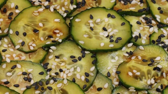 rotating korean cucumber salad oi muchim with sesame seeds and soy sauce. macro video of marinated vegetable slices in asian dressing. concept of korean cuisine, food blog, healthy eating