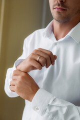 Close-up of groom’s hand with wedding ring