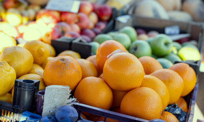 Fresh mandarin oranges or tangerines fruit with leaves in boxes at the open air local food market....