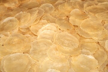 Detailed view of uncooked emping crackers made from melinjo seeds, a traditional Indonesian snack ingredient before frying.
