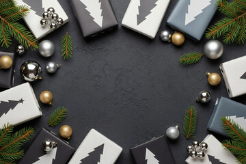 A Minimalist Christmas Frame or Wreath of Gift Boxes with Christmas Tree Patterns, Ornaments, and Pine Branches on a Dark Textured Background with Copy Space
