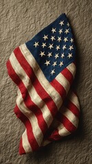Vintage American flag draped over textured background illustrating patriotism and history