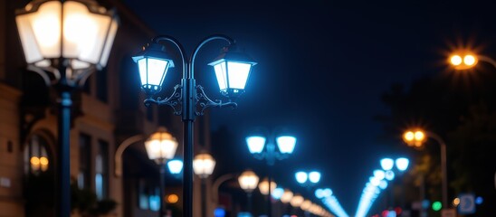 Illuminated street lamps line a city street at night.