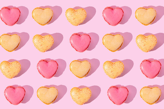 Heart shaped macarons arranged in a pink patterned flat lay
