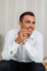 Smiling man with black ring in white shirt — modern groom look