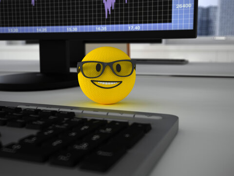 Knitted 3d emoji with glasses smiling on office desk by computer monitor