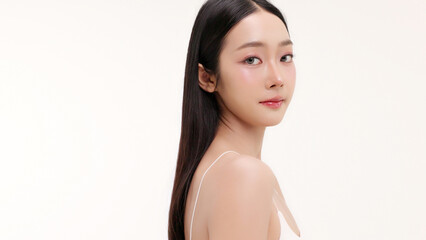 Skincare commercial of featuring a young Asian woman applying natural cosmetic cream in a soft, minimal studio setting. Ideal for promoting beauty, self-care, and organic skincare products.