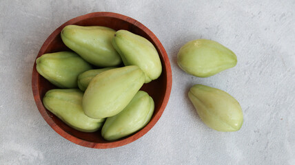 Baby chayote (labu siam) on wooden bowl with greybackground. top view