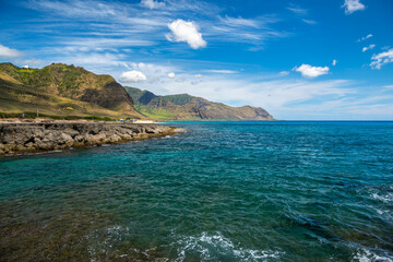 Fototapeta premium A bright view of the rugged coastline on the west side of Oahu, Hawaii, near Makua Beach.