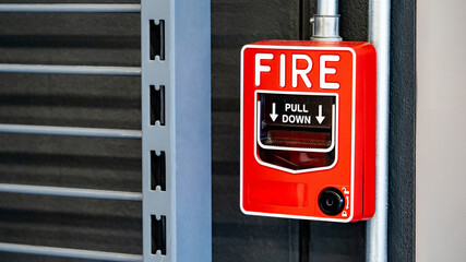 Fire alarm switch on the wall in warehouse or factory building. Emergency fire warning system equipment
