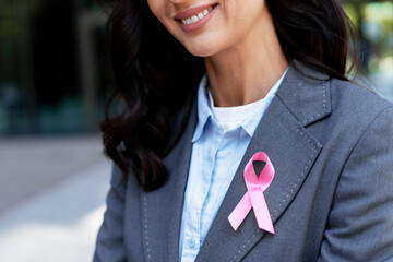 Businesswoman wearing pink ribbon for breast cancer awareness