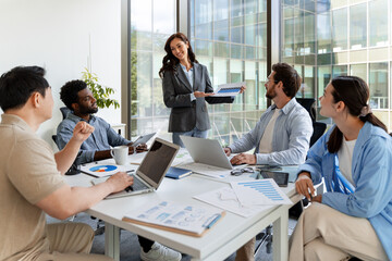 Businesswoman showing infographic to colleagues during a meeting