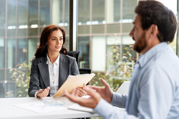 Businesswoman and businessman discussing during a meeting in a modern office