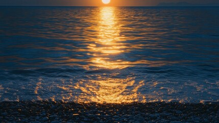Golden sunset reflecting on the ocean waves meeting a rocky beach shoreline in a serene seascape scene