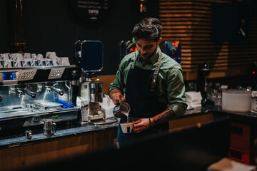 A professional barista skillfully pours milk into coffee, crafting a latte in a cozy cafe.