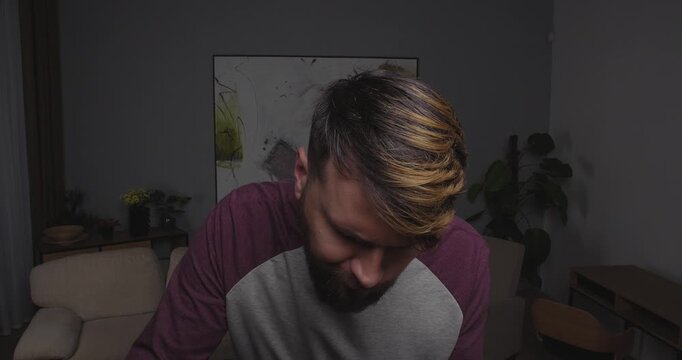 Close-up of a bearded blond man funny eating eating salad and droppind his fork in shock, looking to the camera, window or tv, standing in a room at home with bizarre face.