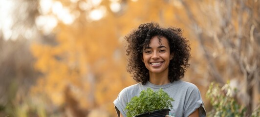 The woman holding a pot of fresh herbs in a vibrant autumn garden.