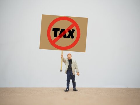Mini toy of action figure at outdoor with blurred background. Miniature photography conceptual design. No Tax regulation poster.