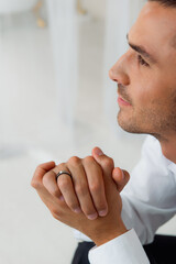 Close-up of elegant men's ring and profile view of man in white shirt