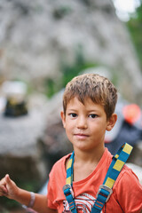 Portrait of confident boy in climbing harness before outdoor adventure