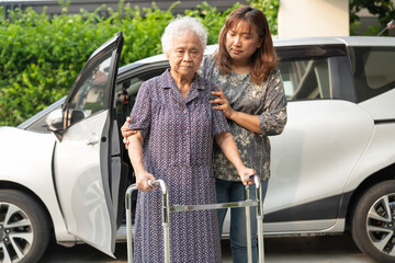 Caregiver help Asian elderly woman disability patient get in her car.