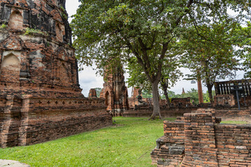 Ancient brick temple ruins with trees in Ayutthaya Historical Park, Thailand