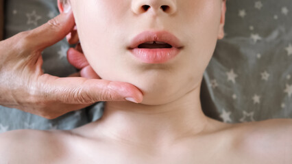 The masseur is massaging child's face. A session of therapeutic lymphatic drainage massage....