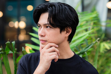Thoughtful young man looking away, deeply suspicious and lost in thought after seeing ex-girlfriend...