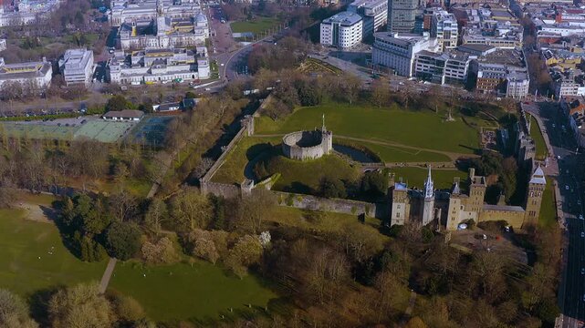 4K drone view of Cardiff Castle&rsquo;s Norman motte and bailey and Gothic Revival palace in Bute Park, ringed by Cardiff city centre &mdash; an iconic Welsh capital landmark and green urban oasis.