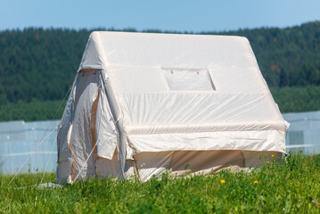 A white tent is sitting in a grassy field