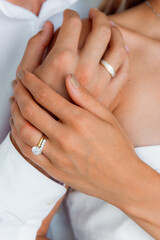 Close-up of Bride and Groom Holding Hands with Wedding Rings