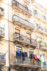 Clothes hanging from balconies in narrow street of barcelona, spain