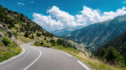 Naklejka premium Winding mountain road offers breathtaking views of lush greenery and stunning blue skies across serene landscape